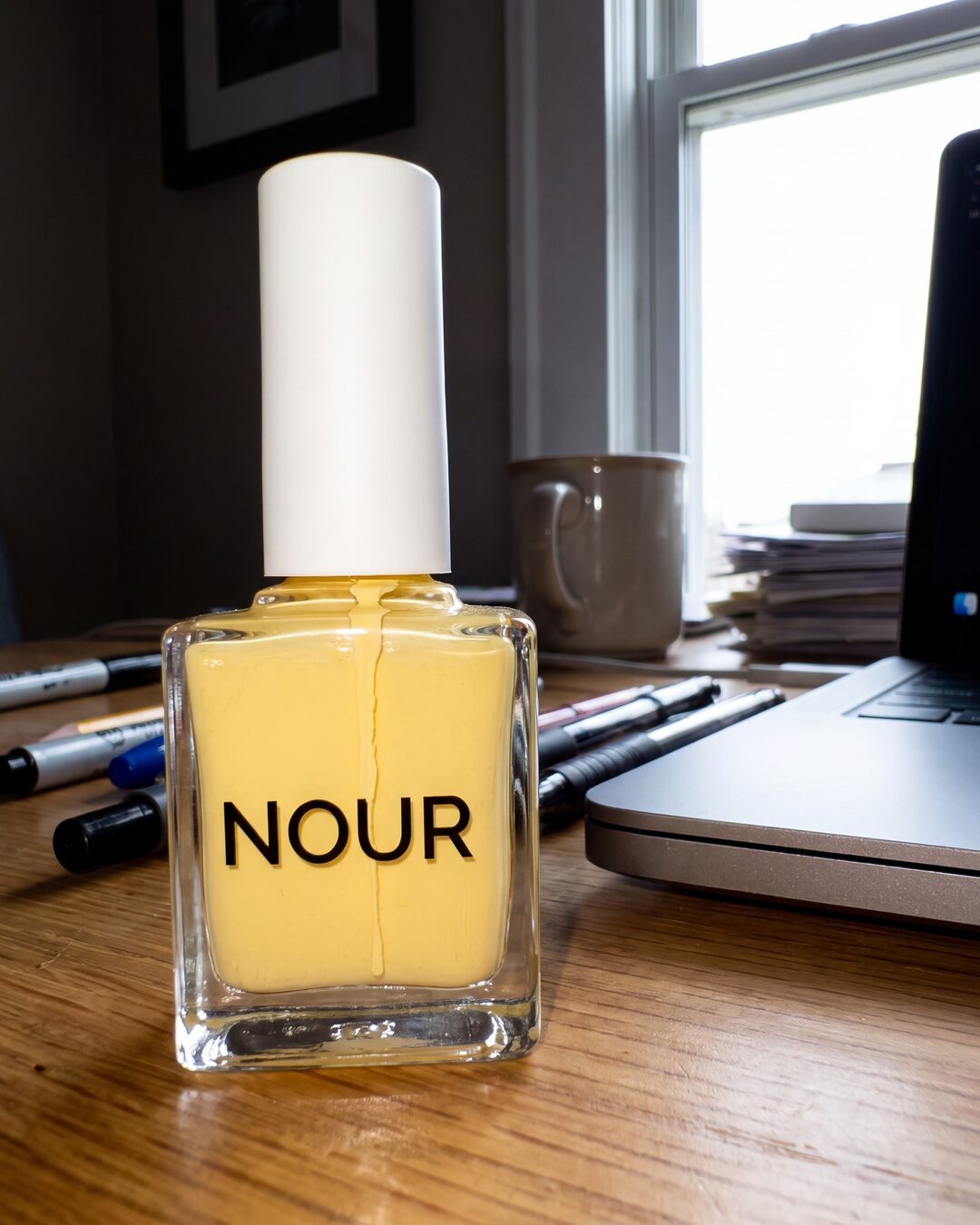 NOUR perfume reference photographed on a desk